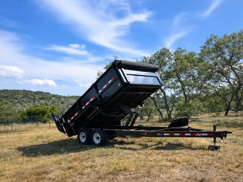 Black dump trailer on grassy field